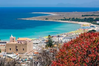 a view of a town with a beach and the ocean at Perla di Mare Appartamenti in Castelluzzo