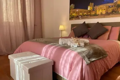 a pink bed with two stuffed animals on top of it at Casa Vacanze Antico Cassaro in Palermo