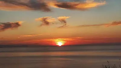 a sunset over the ocean with clouds in the sky at Villa Verde in Cefalù