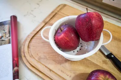 two apples in a bowl on a cutting board at Terrazza al Capo by Wonderful Italy in Palermo