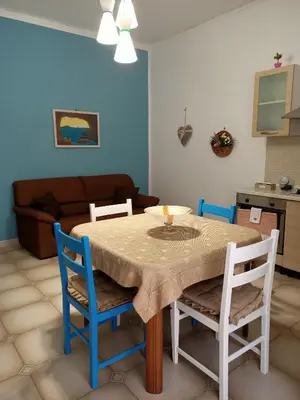 a dining room with a table with chairs and a couch at La Casetta di Nonna Anna in Palermo