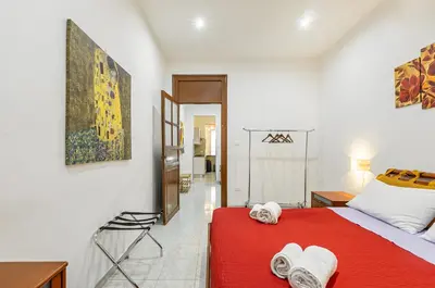 a bedroom with a red bed with towels on it at GuestHost - Corso dei Mille Railway Apartment in Palermo