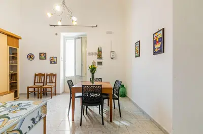 a dining room with a table and chairs at GuestHost - Corso dei Mille Railway Apartment in Palermo