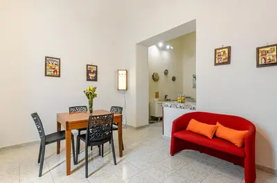 a living room with a table and a red couch at GuestHost - Corso dei Mille Railway Apartment in Palermo