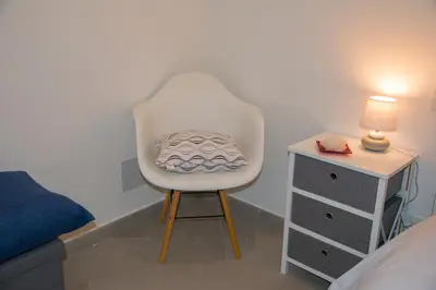 a white chair in a bedroom with a bed and a nightstand at MONDELLO MANICK MARE in Palermo