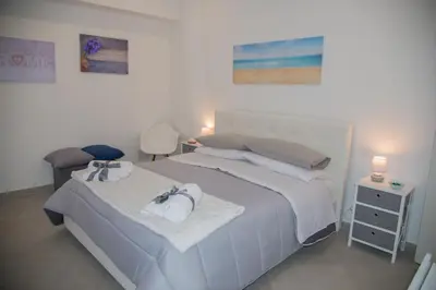 a bedroom with a large white bed with towels on it at MONDELLO MANICK MARE in Palermo