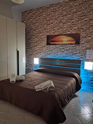 a bedroom with a large bed with a brick wall at Monfenera Apartment 3 in Palermo