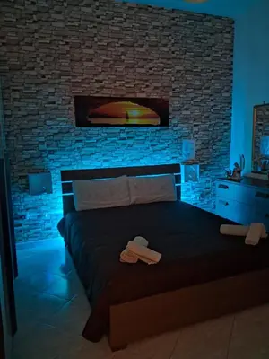 a bedroom with a bed with a brick wall at Monfenera Apartment 3 in Palermo