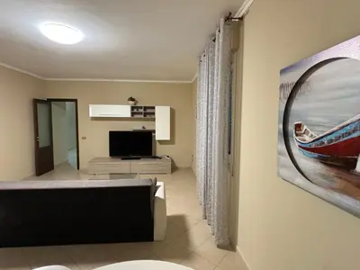 a living room with a couch and a television at Casa Olivella in Santa Flavia