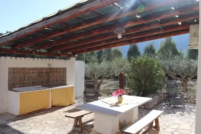 a patio with a table and a kitchen with a view at Baglio Cracchiolo Casa Baldo in San Vito lo Capo