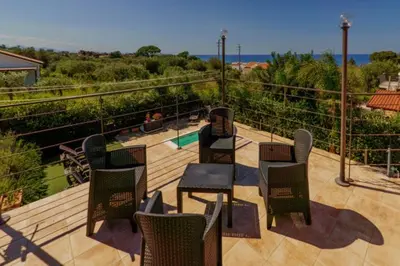 a patio with chairs and tables on a deck at Villa Giorgia 2020 in Cefalù