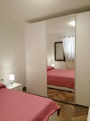 a bedroom with two beds and a mirror at Villa Giorgia 2020 in Cefalù
