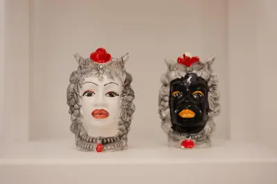 a couple of vases with a mask on them at Briogna by Maravigghia Palermo in Palermo