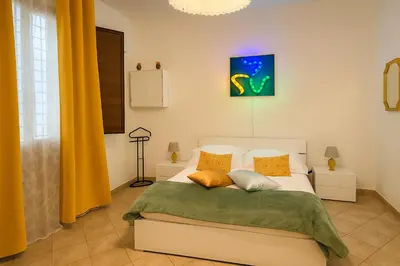 a bedroom with a white bed with yellow pillows at Briogna by Maravigghia Palermo in Palermo