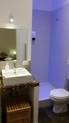 a bathroom with a white sink and a toilet at Palermo Rooms in Palermo