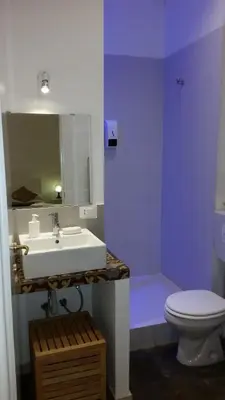 a bathroom with a white sink and a toilet at Palermo Rooms in Palermo
