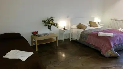 a bedroom with a bed and a table with a vase of flowers at Palermo Rooms in Palermo
