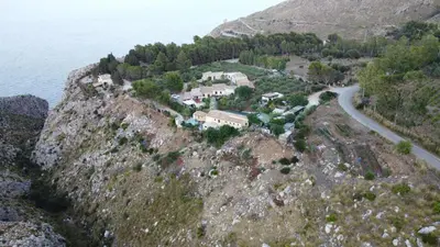 a house on the side of a mountain with a road at Baglio Cracchiolo da Tuzzo - Casa Il Limone in San Vito lo Capo