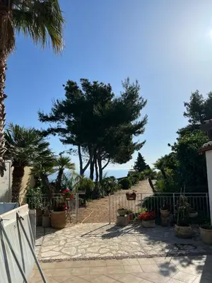 a gate with plants and trees on a beach at Baglio Cracchiolo da Tuzzo - Casa Il Limone in San Vito lo Capo