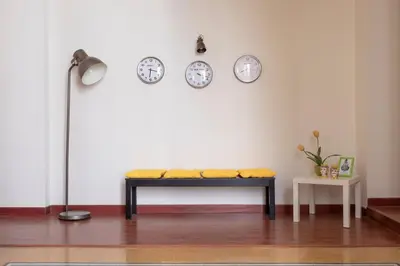 a bench in a room with clocks on the wall at Casa Gagliani, a Liberty house in the old downtown in Palermo