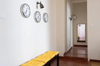 a living room with clocks on the wall and a bench at Casa Gagliani, a Liberty house in the old downtown in Palermo