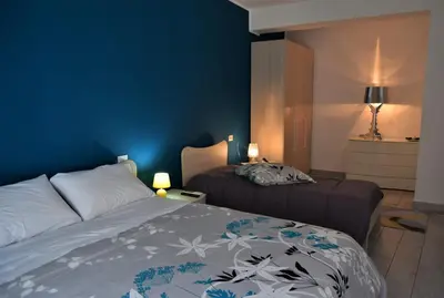 a bedroom with two beds and a blue wall at L'Antico Borgo di Segesta in Calatafimi