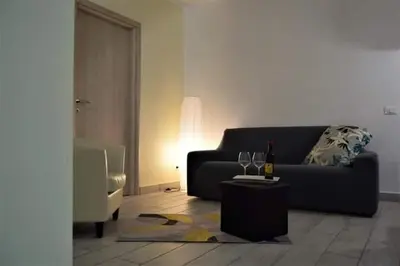 a living room with a couch and a table with wine glasses at L'Antico Borgo di Segesta in Calatafimi