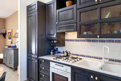 a kitchen with dark wood cabinets and a sink at VILLA GIAGGIA - VICINO IL MARE in San Vito lo Capo