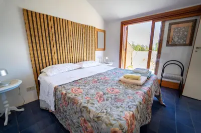 a bedroom with a bed with a floral bedspread at Villa Claudia in Scopello