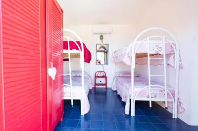 a bedroom with two bunk beds and a blue tile floor at Villa Claudia in Scopello