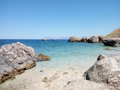a beach with rocks in the water on a clear day at Villa Claudia in Scopello