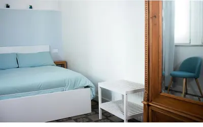 a bedroom with a bed and a chair and a mirror at B&B Babbaluci - Centro Storico in Palermo