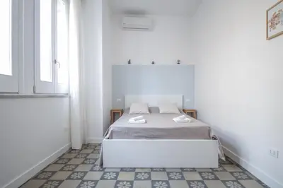 a white room with a bed and a window at B&B Babbaluci - Centro Storico in Palermo