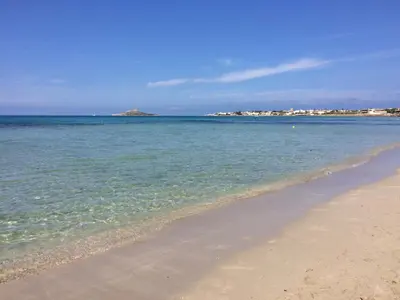 a beach with the ocean and buildings in the background at Villetta Aurora in Isola delle Femmine