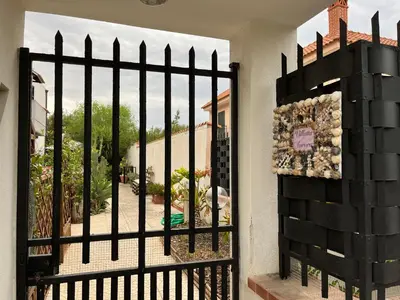 a iron gate with a view of a yard at Villetta Aurora in Isola delle Femmine