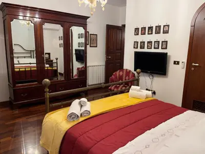 a bedroom with a bed with towels and a tv at Villetta Aurora in Isola delle Femmine
