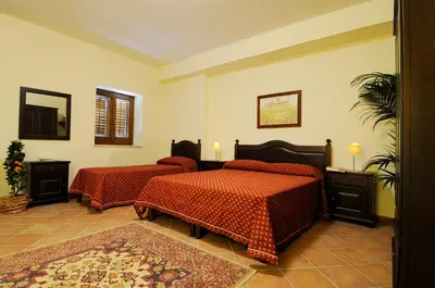a hotel room with two beds and a mirror at Agriturismo Masseria La Chiusa in San Giuseppe Jato