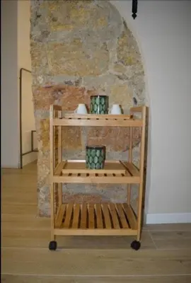 a wooden shelf with vases on it in front of a stone wall at Antico vicolo di ballarò in Palermo