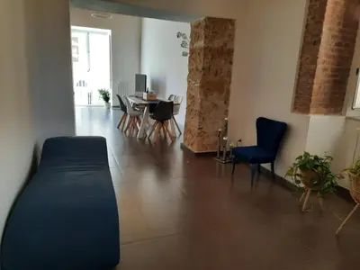 a living room with a couch and a table and chairs at A Casa del Genio in Palermo