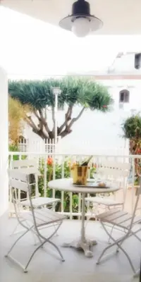 a table and chairs on a patio with a tree at villa coral mondello in Palermo