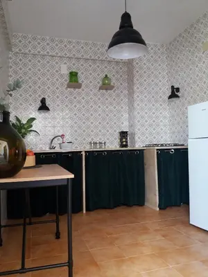 a kitchen with green counters and a white refrigerator at villa coral mondello in Palermo