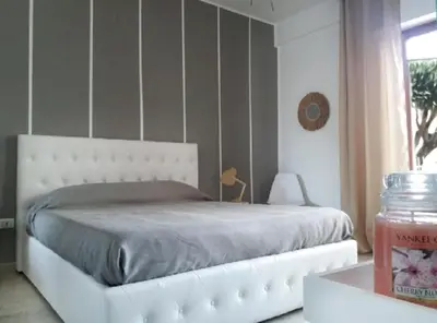 a bedroom with a white bed and a window at villa coral mondello in Palermo