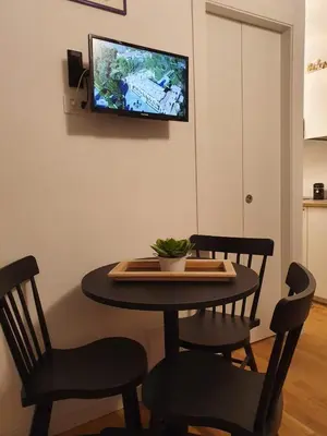 a dining room table with two chairs and a tv on the wall at HoliDay in Palermo