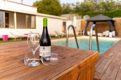 a bottle of wine and a glass on a wooden table at Panorama del golfo in Balestrate