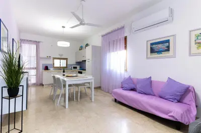 a living room with a purple couch and a table at Panorama del golfo in Balestrate