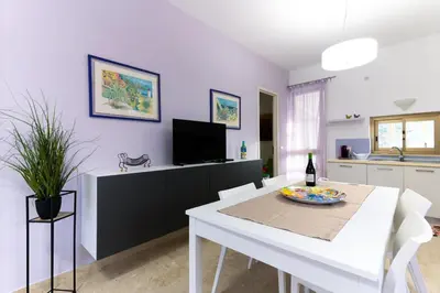 a kitchen and dining room with a table and a tv at Panorama del golfo in Balestrate