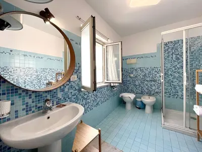 a bathroom with a sink and a toilet and a mirror at Solemar Sicilia - Palazzo Massimo in Palermo
