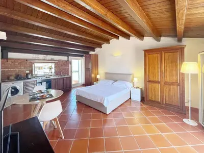 a large bedroom with a bed and a kitchen at Solemar Sicilia - Palazzo Massimo in Palermo