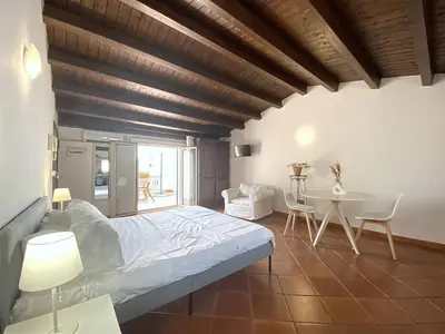 a bedroom with a bed and a table and chairs at Solemar Sicilia - Palazzo Massimo in Palermo