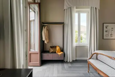 a bedroom with a mirror and a bed and a window at Villa Masetta - Luxury Suites in Mondello